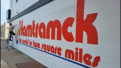 Muralist updates a vintage Hamtramck slogan