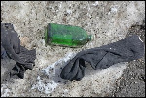 Above: Empty liquor bottle? Check. Pair of socks. Check on that too. Below: Ten-pound bag of chicken parts? Looks like we have all the makings of a party here. Just some of the predictable and strange items you can find on our streets and parking lots after winter blows over.
