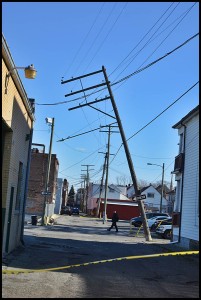 A utility pole leans toward falling over behind Mostek and Paint Company.