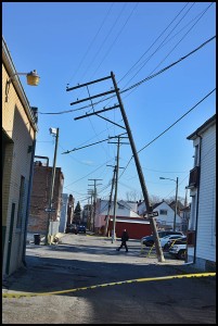 A utility pole leans toward falling over behind Mostek and Paint Company.