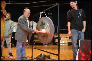 Hamtramck Public School Board Treasurer Dennis Lukas tries his hand at playing a gong that was one of several instruments donated by the Hamtramck Music Festival to the public school district. Organizers of the festival donated $5,000 worth of instruments and $5,000 to go toward a new public address system for the auditorium at Hamtramck High School. 